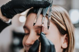 A hairstylist showing a diagram of face shapes to a person with different haircut examples.