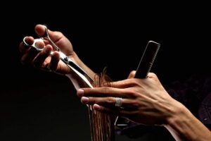 A person examining their hair in a well-lit bathroom mirror with visible strands in their hand.